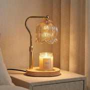 JONJOLI Classic Candle Warmer in gold beside a jar candle